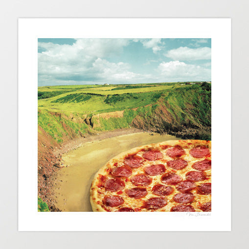 Coastal Pizza Bay surreal art print — a large golden pepperoni pizza sitting at landscape scale in a dramatic coastal bay with green clifftops rocky headlands and a sweeping sandy cove below a cloudy blue sky, food and coastal surrealism wall art for kitchens beach houses pizzerias and seaside cafe interiors