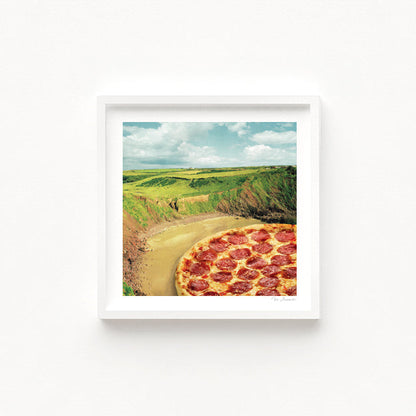 Coastal Pizza Bay art print second view — surreal collage of a perfectly topped pepperoni pizza integrated into a clifftop coastal landscape with rolling green headlands and sandy shore, quirky food art for beach house decor holiday homes seaside restaurants and pizza lover gift ideas