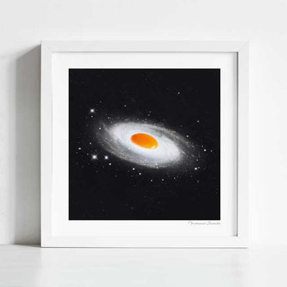 Cosmic Egg art print framed view — vintage surreal collage of sunny side up egg as a radiant celestial body in deep space, quirky galaxy food wall art for cafés and gallery walls