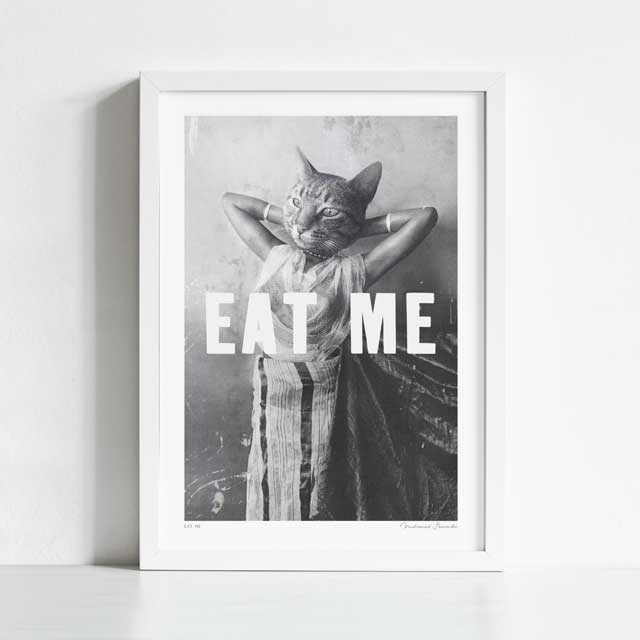 Eat Me art print framed view — surreal vintage monochrome collage of a burlesque pin-up figure with tabby cat head and bold block capital text, funny dark humour cat wall art for gallery walls and bold eclectic spaces