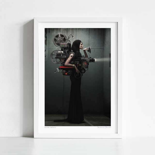 Madame Cinematic art print framed view — surreal dark fashion collage of a hooded woman as a vintage cinema projection machine with film reels and projector lens against industrial concrete, steampunk noir wall art for home cinemas and gallery walls