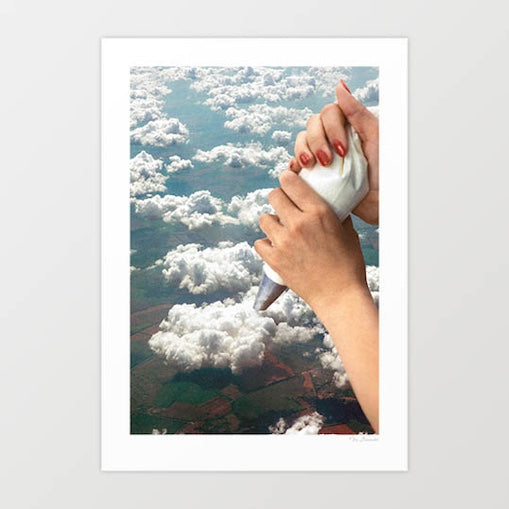 Piping Clouds surreal art print — elegant woman's hands with terracotta red manicured nails holding a white piping bag with silver nozzle, piping onto vast fluffy white cumulus clouds viewed from high altitude, green and brown patchwork fields far below, the cloudscape treated as a patisserie surface, surreal dreamy kitchen and cafe wall art for bakeries, patisseries, hotels and wellness interiors