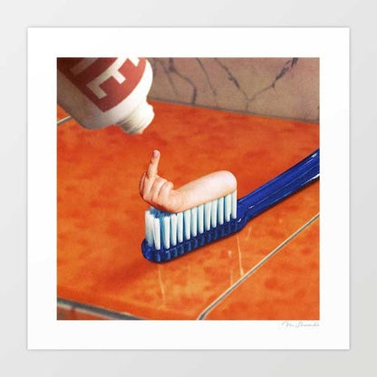 Up Your Mouth art print square format — close up of a blue toothbrush with a miniature human hand flipping the middle finger from the bristles on a warm terracotta marble surface, surreal dark humour bathroom decor for dentists dental waiting rooms and funny wall art enthusiasts